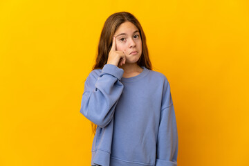Child over isolated yellow background thinking an idea