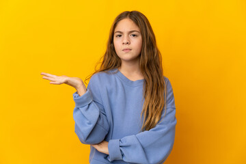 Child over isolated yellow background having doubts