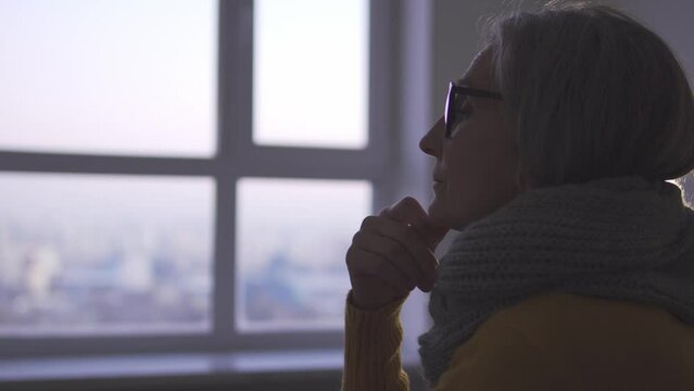 Thoughtful lonely woman feeling sadness sitting in empty room, social insecurity