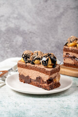Chocolate and profiteroles cake. Layered cake with chocolate and cream on plate on stone background. close up
