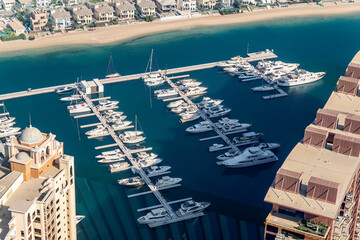 fast boats and luxury yachts are parked in the port at the pier near beach. View from above.