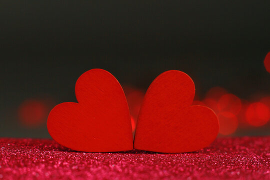 Macro photograph of red hearts on a dark background with blurred lights. Hearts on a brilliant background with space for a copy, St. Valenin's Day, Valentine's Day, Wedding, Mother's Day. The concept