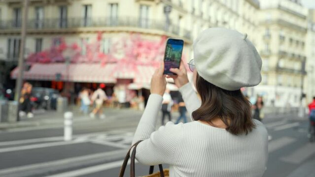 Attractive tourist taking photo on smartphone near cafe by the road