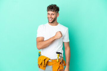Young electrician blonde man isolated on green background celebrating a victory - obrazy, fototapety, plakaty