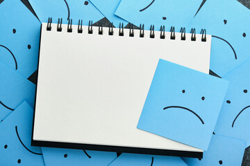 Blue sticky notes blank with drawing sad face on black background with copy space ready for your...