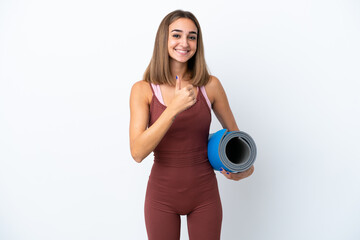 Young sport caucasian woman going to yoga classes isolated on white background giving a thumbs up gesture