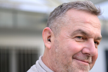 Obraz premium Side view of a man with a hearing aid in his ear