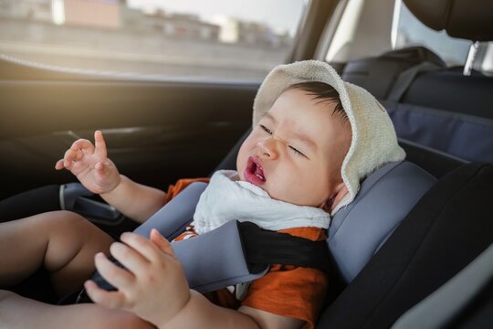 The toddler boy is crying in the car seat while going to school. feel uncomfortable while the car is moving. bad mood, negative emotion. close up.