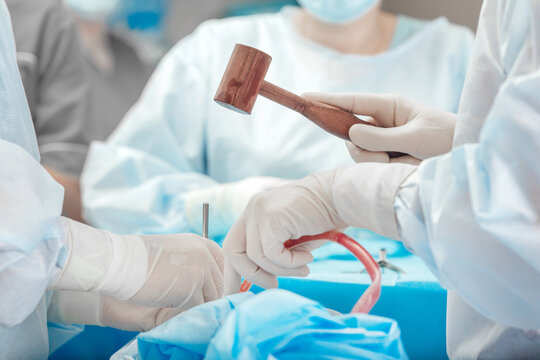 A surgeon uses a medical wooden mallet during an operation