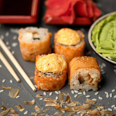 Baked hot sushi roll set with omelet. Healthy and useful feed. Isolate on dark background. Japanese cuisine. Photo for menu. Top view. Soft focus. Copy space.