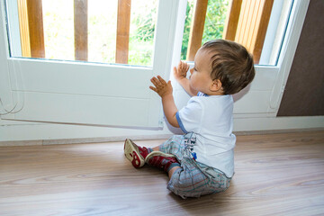 petit enfant ouvrant une fenêtre