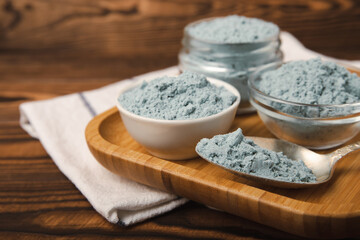 Blue Spirulina algae powder on brown texture background. Diet and detox concept.Natural vegan superfood. Food supplement. Copy space. Place for text.