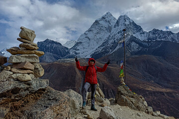 Hiker woman posing for the camera with Ama Dablam mountain in the background at Khumbu valley - trekking to the Everest Base camp, the Himalayas, Nepal.