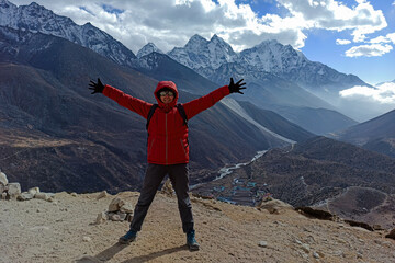 Hiker woman posing for the camera with a mountain in the background at Khumbu valley - trekking to the Everest Base camp, the Himalayas, Nepal.
