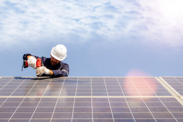 Male technician installing solar panel using electric drill securing solar system installation structure outdoors working outdoors : concept of renewable energy construction