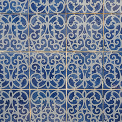 Fragment of building wall with colorful ceramic wall tiles, Azulejo close up. Abstract decorative background, textured ornate pattern for design or backdrop. Traditional ornate Portuguese architecture