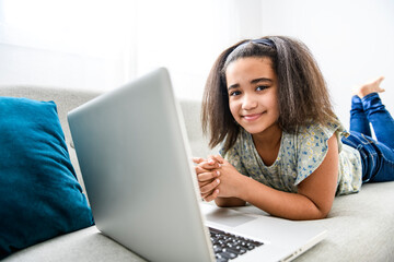 portrait of cute child using laptop on sofa