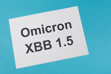 Top view of paper with omicron xbb lettering on blue background.