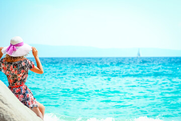 Fototapeta na wymiar A Happy girl on the shore of the sea in travel vacation