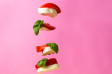 Flying caprese salad and pink background
