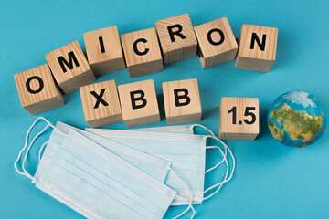 Top view of wooden cubes with omicron lettering near medical masks on blue background.