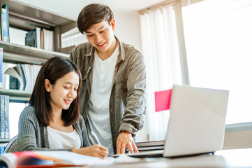 Two students are reading and discussing about exam preparation, presentation, study for test preparation in library.Education, Learning, Student, Campus, University, Lifestyle concept.