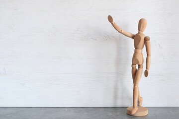 Wooden mannequin, male demonstrates with his hands. Copyspace.