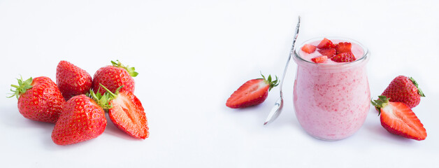 Natural milk yogurt with strawberry in the glass jar on the white background. Copy space. Banner.