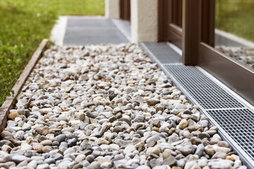 French drain with Drainage Stones River Rock Gravel or Crushed Stone by House Wall Window for Water...