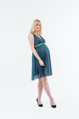 A beautiful pregnant girl poses in the studio