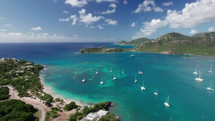 The drone aerial footage of Pigeon Point beach and Deep Bay beach in Antigua. The widely turquoise bay is surrounded by beautiful undulating slopes, and the iconic Fort Barrington.