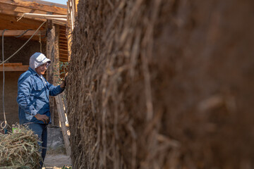 a person building with mud bioconstruction permaculture