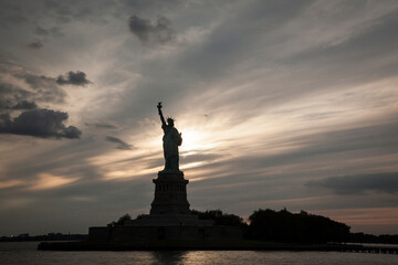 Fototapeta premium Silhouette of the Statue of Liberty at dusk, New York