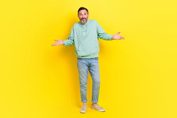 Full length photo of funky man wear trendy clothes raise hands show no answer sorry stand empty...
