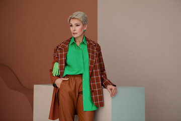 Fashion woman with short hair in stylish fashionable business clothes, brown checkered jacket,...