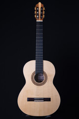Fototapeta na wymiar Classical guitar top isolated on black background, view from the top side. Beautiful Brazilian wood - Pau Ferro on the back and spruce on the top. Classic acoustic guitar concept. 