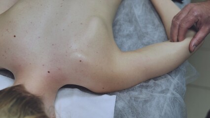 Fototapeta premium A masseur massages a girl's shoulder.