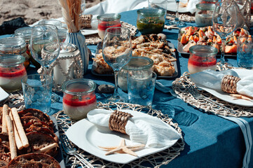 Beautiful table setting with plate, white napkin, braided decorative ring and starfish. Picnic in the style of boho. Closeup.