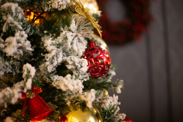 Christmas tree in red and gold toys. Blurred bokeh background.