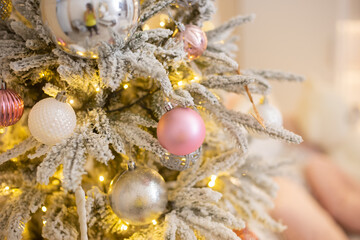 Christmas tree of pink and white toy balls. Blurred bokeh background.