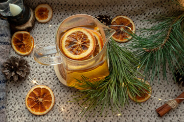 Green tea in a transparent, glass teapot, dried oranges and Christmas atmosphere, Christmas tree branches