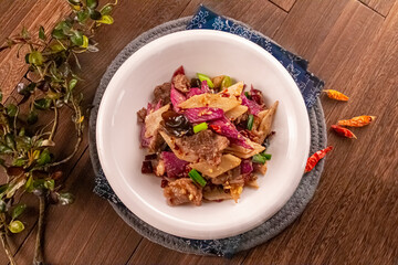 Dry Pot Hunan Style chilli Pork Intestines served dish isolated on wooden table top view of Hong Kong food