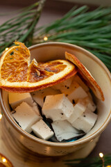 Marshmallows in a cup, dried orange and Christmas tree branches near the cup