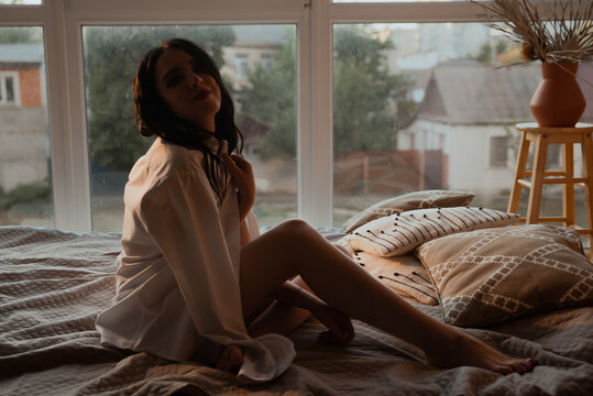 Sexy young brunette girl in black lingerie in loft photo studio