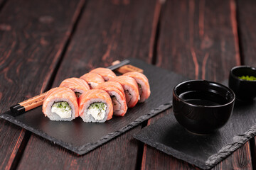 Roll with fish sushi with chopsticks - asian food concept