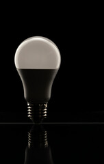White LED lamp on a black background. The concept of saving electricity.
