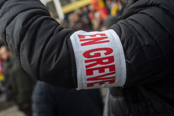 Closeup of man protesting in the street with cut and text in french : en greve, traduction in english : striking