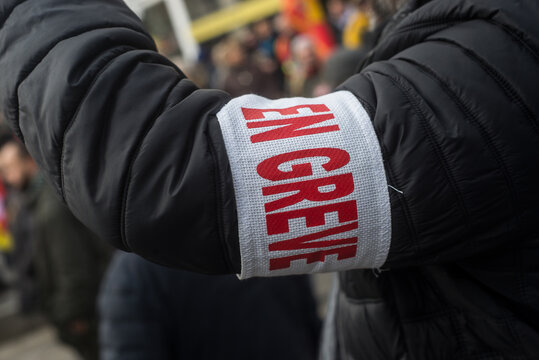 Closeup of man protesting in the street with cut and text in french : en greve, traduction in english : striking