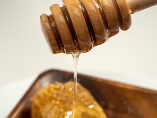 With honeycombs and a wooden spoon for honey in a wooden cup. Honeycombs and honey.