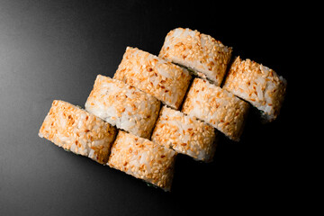 top view on sushi rolls california with salmon, cream cheese, cucumber, sesame seeds on dark background.